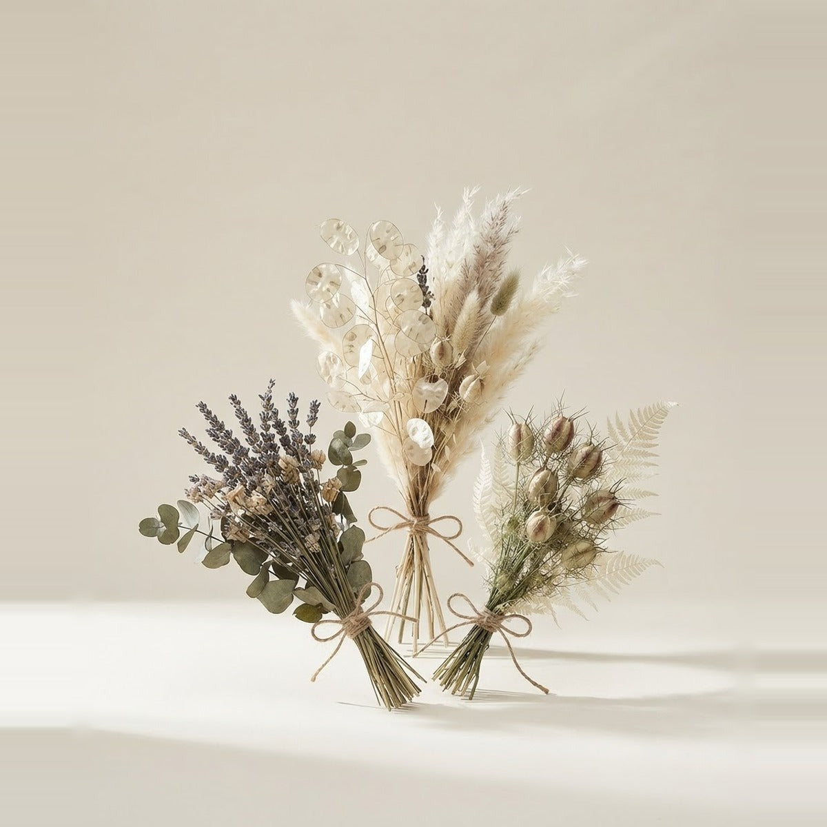 Dried & preserved flowers — three bunches of dried and preserved flowers in muted natural tones, loosely tied