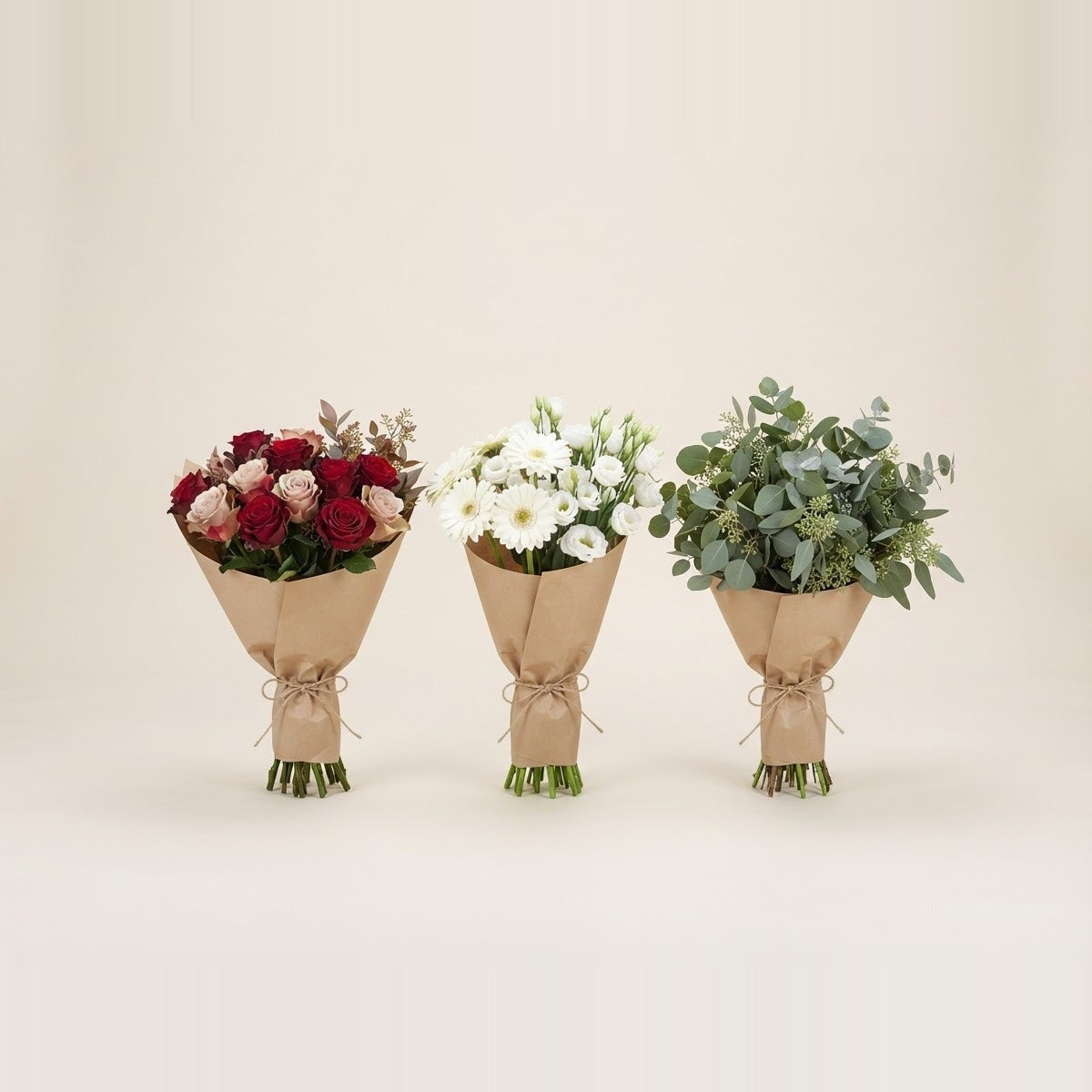 Fresh cut flowers — a loose bunch of mixed fresh cut flowers - roses, chrysanthemums and eucalyptus - lying beside a cream ceramic vase