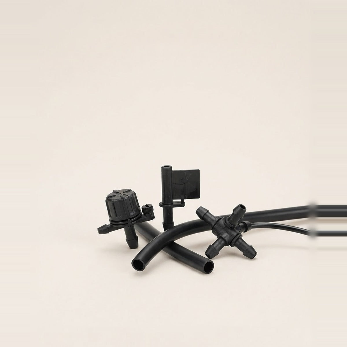 Drippers & Emitters — three drip irrigation emitters and a short length of black tubing