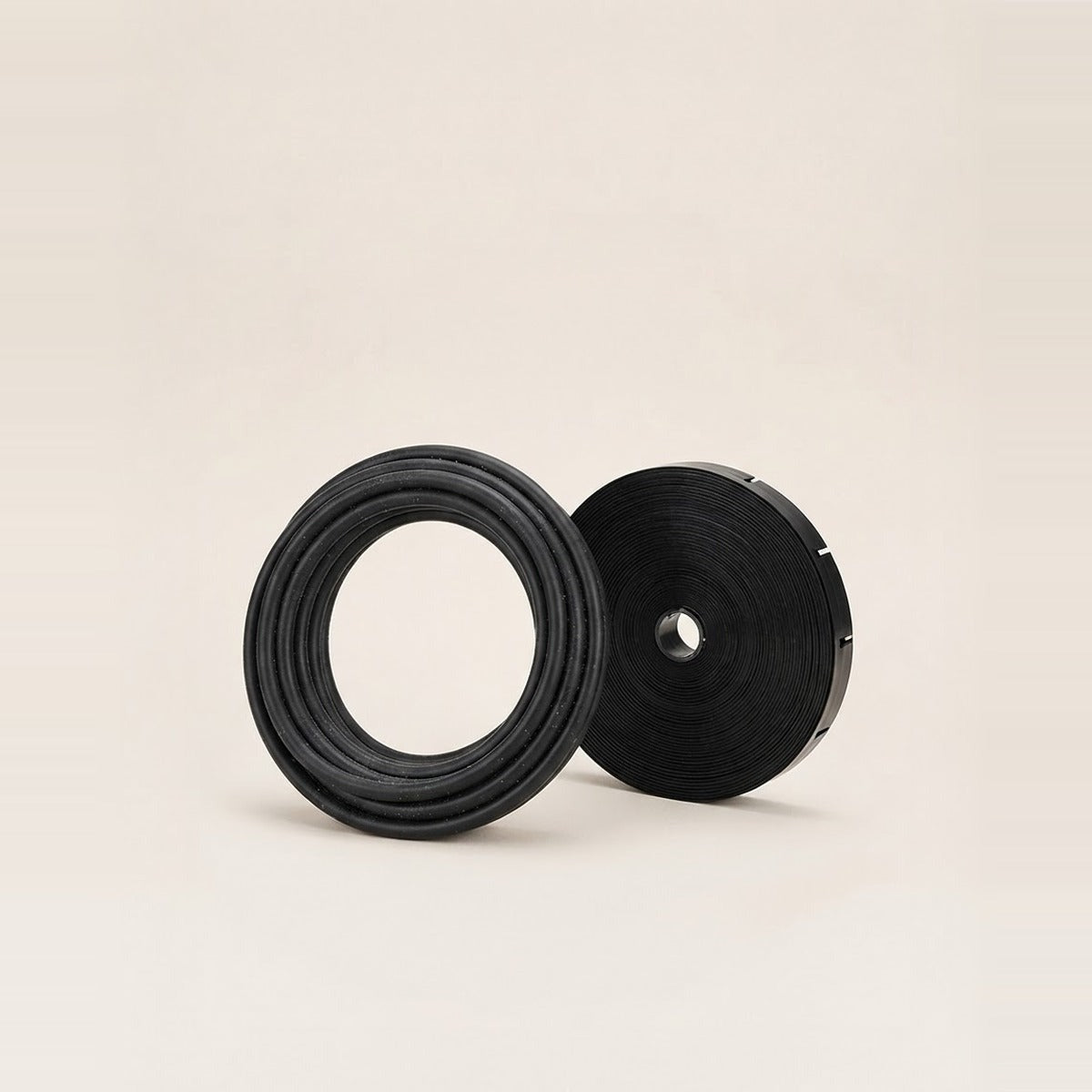 Drip Tubing & Tape — a coil of black drip irrigation tubing beside a roll of flat drip tape