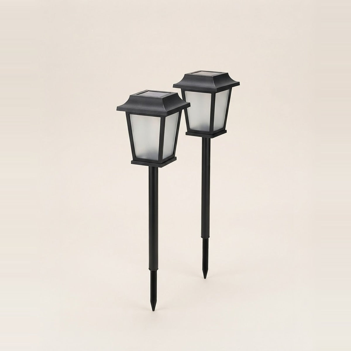 Solar & Garden Lighting — solar garden lights - two stake path lights and a hanging solar lantern glowing warm, beside a small potted plant